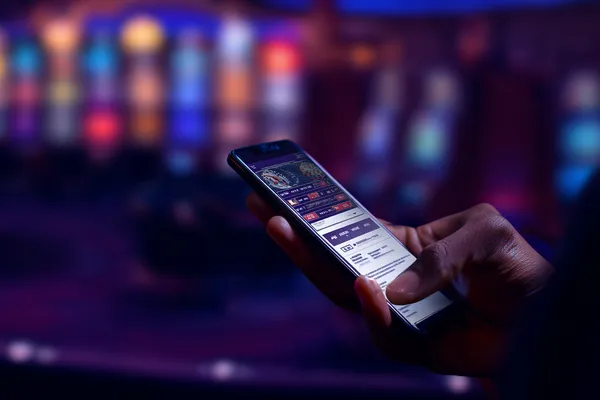 A man focused on his laptop with live stats in the background, highlighting the dedicated sports and gaming features of the FFBETT mobile app.