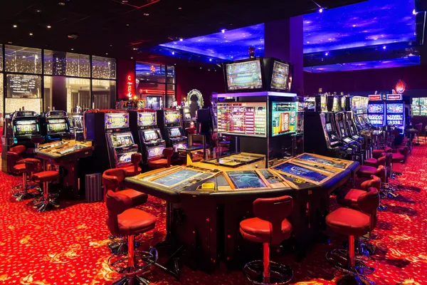 A stylish woman beside vibrant slot machines displaying glowing sevens, showcasing the variety of top slots at FFBETT.