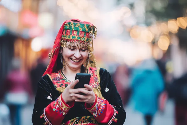 A player using their smartphone during a festive local event, representing FFBETT’s fully mobile-friendly casino.